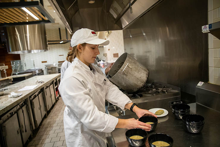 hospitality students work in the kitchen at Century Casino plating bowls of soup