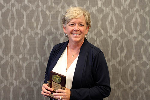 Cindy Gannon poses for a professional photo with her award