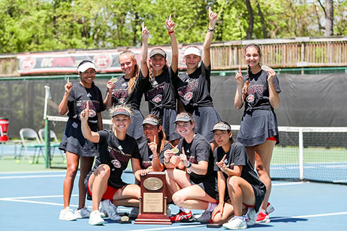 the women's tennis team poses on the tennis court with their OVC trophy