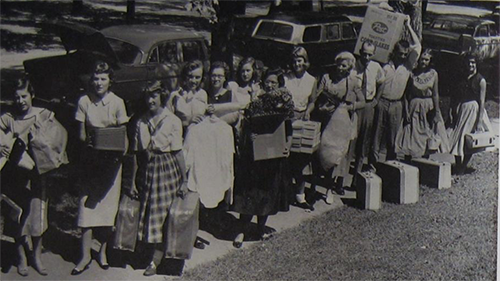 a move in line on Normal street around the 60s era of young women with their luggage