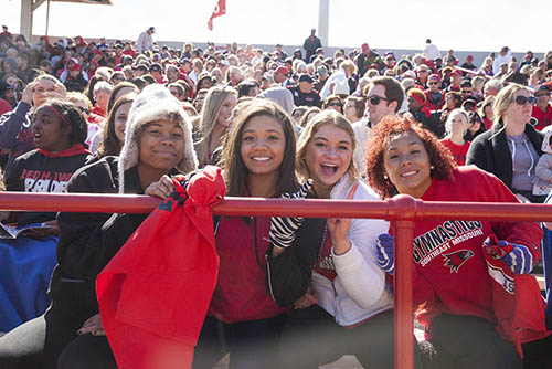 a group of students in the student stands at Houck stadium during homecoming, they are wearing semo gear