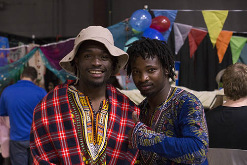 two students in african cultural clothing pose for a photo