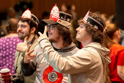 students holding treats and wearing party hats