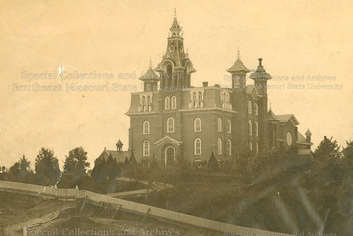 Photo of the Normal School from the 1890s, now surrounded in greenery and trees.