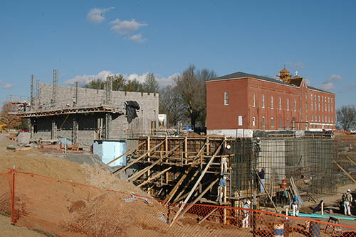 construction of the river campus cultural art center begins. there is concrete support, wooden walls with supports and fresh earth all over