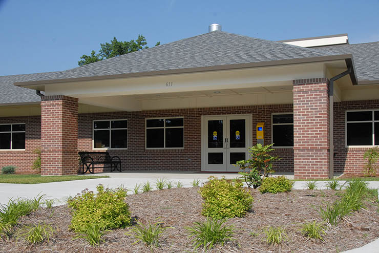 the front of the freshly completed autism center under a bright blue sky