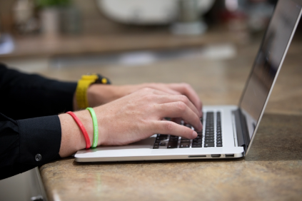 Close up of a student typing on their laptop keyboard. 