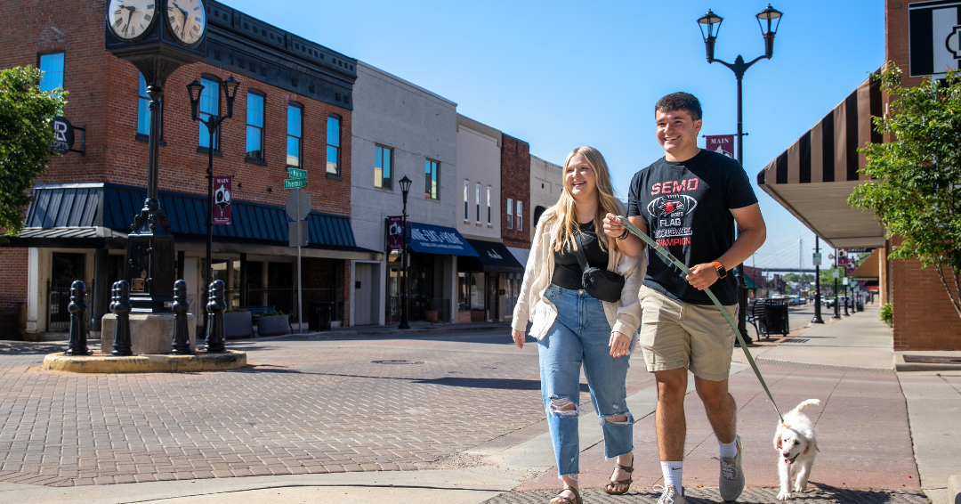 A couple of students walking their dog in downtown Cape Girardeau. 