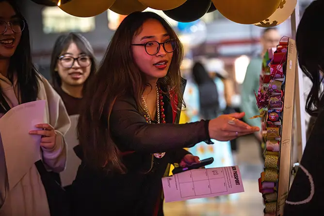 A student reaches for a craft on display at Carpe Diem, an on-campus international student event meant to share cultures.