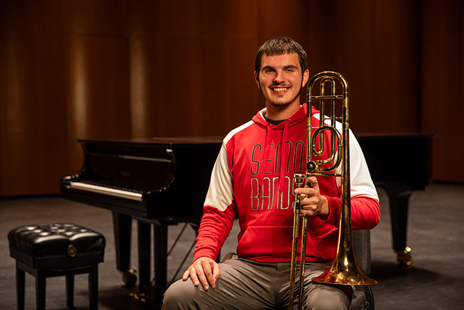 SEMO Alumni Isaac Thorn smiles for a photo holding his trombone.