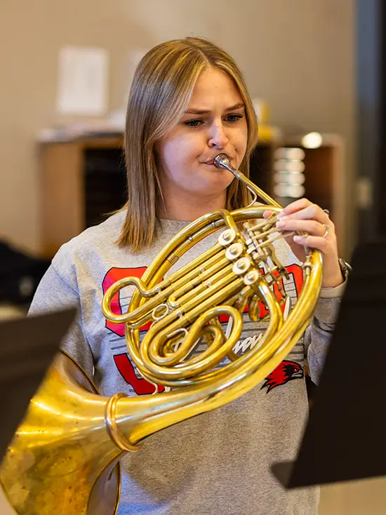 Jordan practices french horn in a performance space on SEMO’s River Campus.