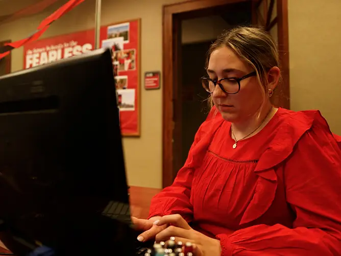 Makayla works at a computer in the University Marketing and Communication department for internship experience for SEMO’s accredited marketing program in Missouri. 