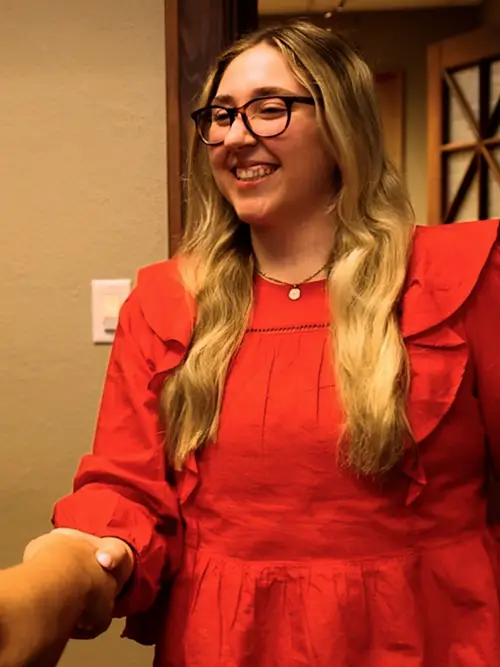 Marketing student at her internship smiles, shaking hands with someone off camera as a part of SEMO’s accredited marketing program in Missouri. 