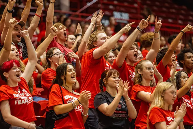 students in the stands in the Show Me Center during Convocation, cheering and raising their hands