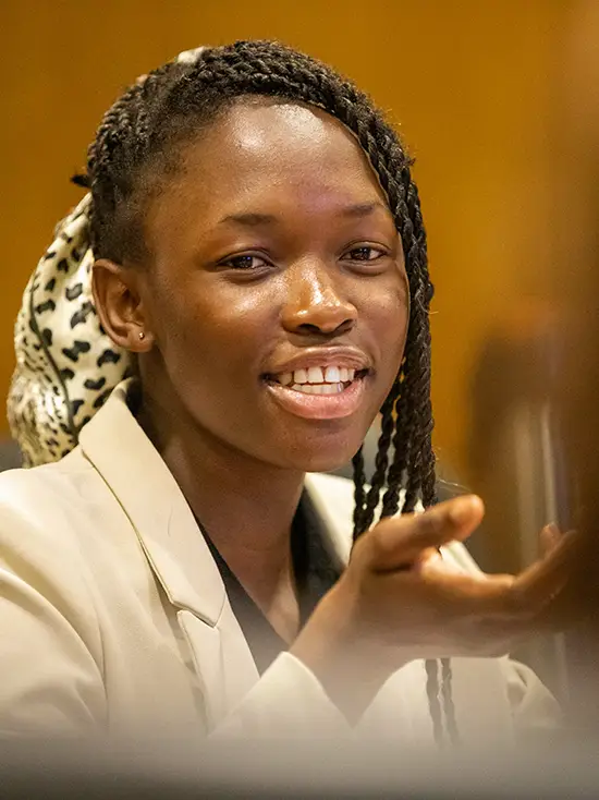 A marketing student speaks at a meeting on campus for experiential learning.  