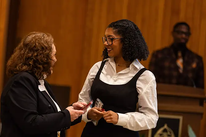 A SEMO marketing student chats with a faculty member at an on-campus networking event.