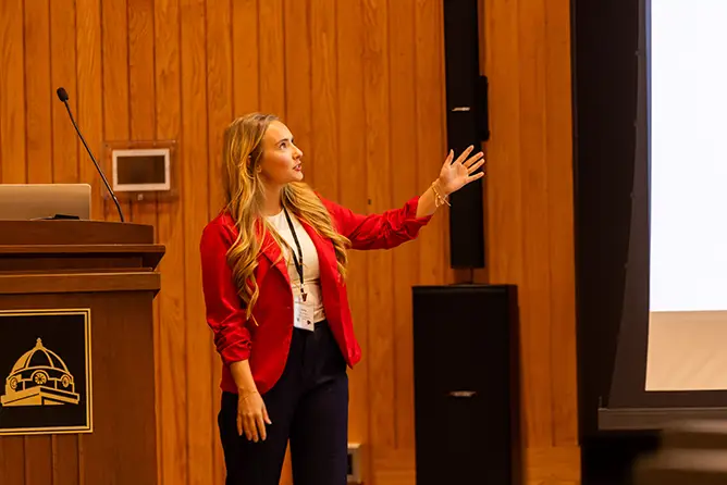  A bs in political science student conducts a presentation on their research to faculty, students and community members.