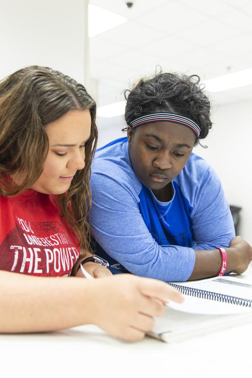 Two students review a textbook in a lounge at the Kennett Regional Campus.