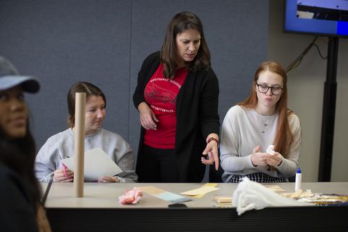 An instructor talks to two students about an assignment.