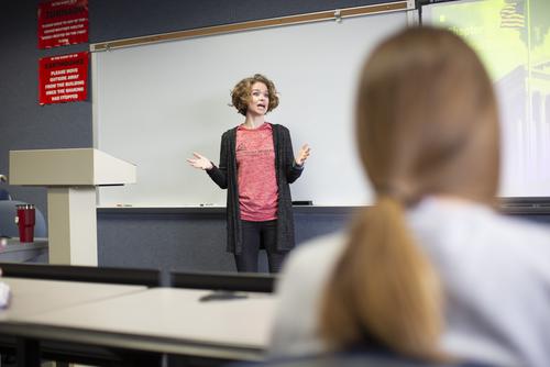 An instructor talks at the front of the class.