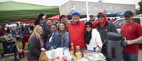 Fans pose together at a tailgate.