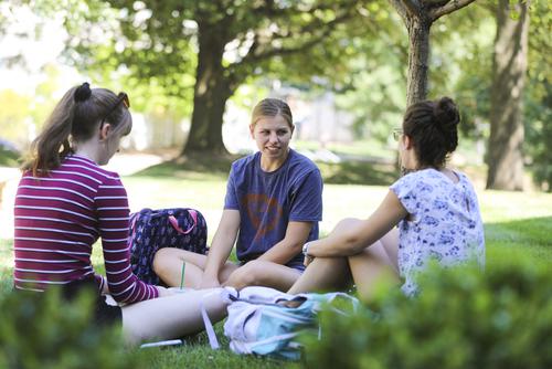 Students sitting in a small group on the campus lawn at Southeast Missouri State University having a conversation.