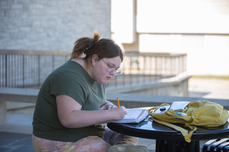 A student does work outside of Kent Library.