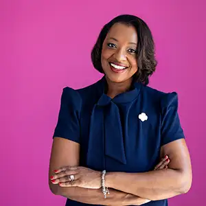 a professional photo of Dr Natissia Small posed against a pink background