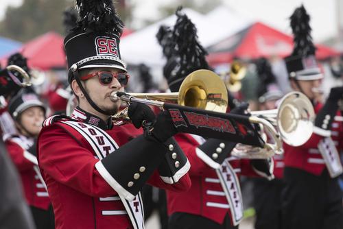 A trombone player marches with the band during the homecoming parade.