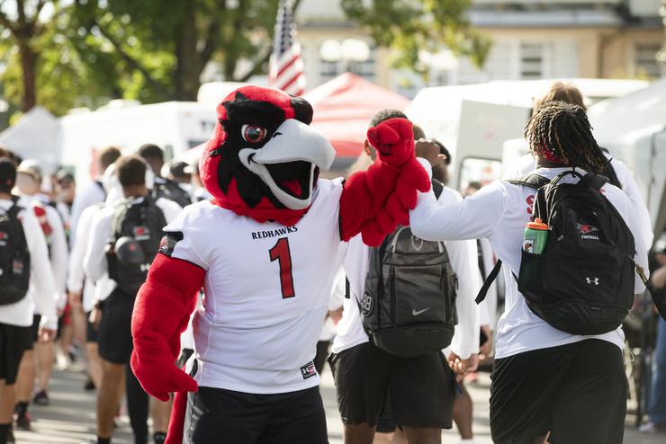 SEMO mascot, Rowdy, bumps arms with an athlete. 