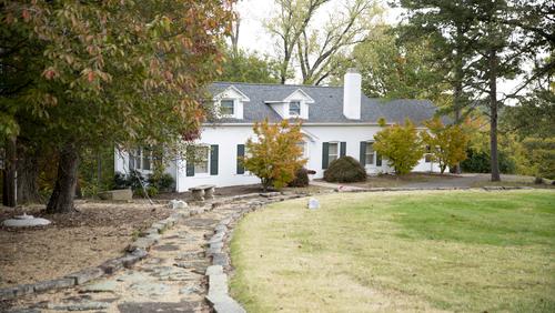  A stone path leads to a historic white colonial home.
