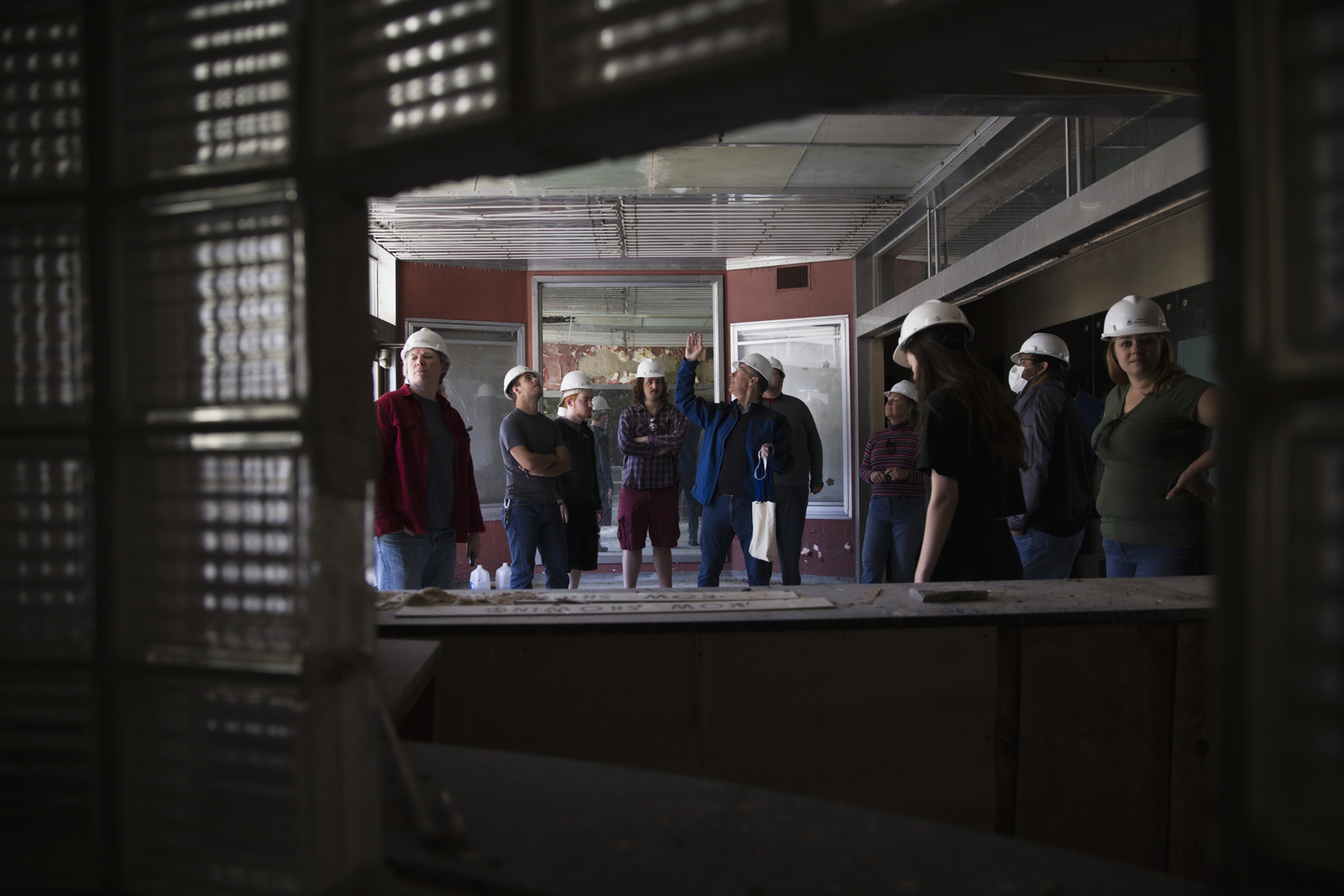 Wearing hardhats in a deteriorating theater, Dr. Hoffman briefs students of the buildings condition.
