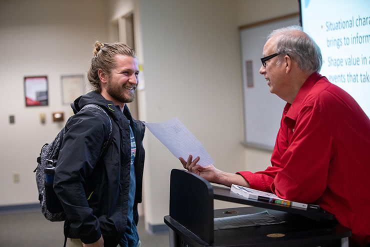 A student listens next to socially-distanced peers in a classroom. 