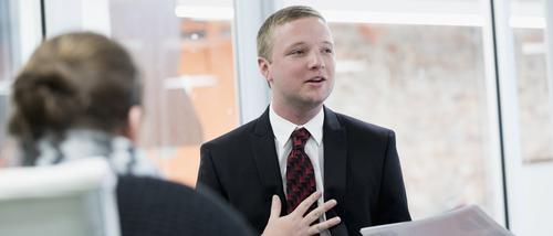 A graduate student gives a presentation in a conference room.