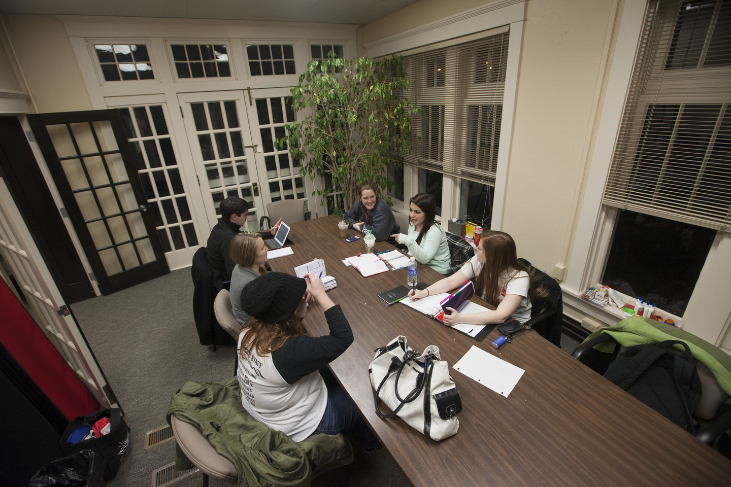 Students gather around a large table inside the Honors House.