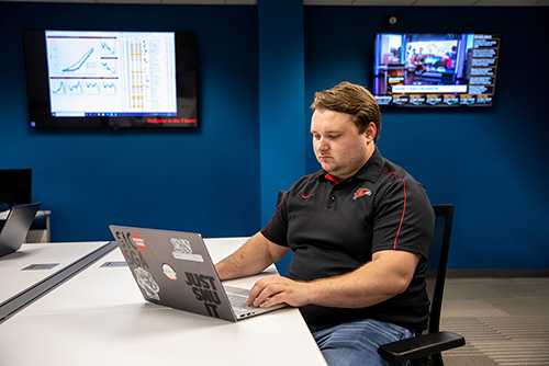 A student works on a laptop in the financial lab of Dempster Hall