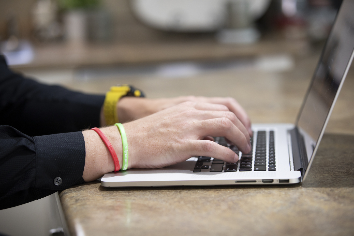 A person's hands typing on a laptop.