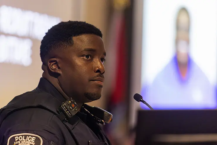 a law enforcement graduate stands at the podium to speak during the ceremony