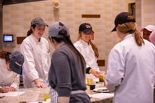 A group of food science students are plating food.