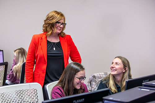 two interior design students smile as they converse with their interior design professor during class in cape girardeau mo. 