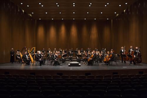 Students smile with their instruments after a performance on stage in Bedell Performance Hall. 