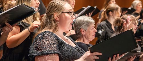 vocal performance majors in the Holland college of arts and music choir sing on stage