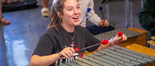 instrumental music education major plays the xylophone in her music teaching class