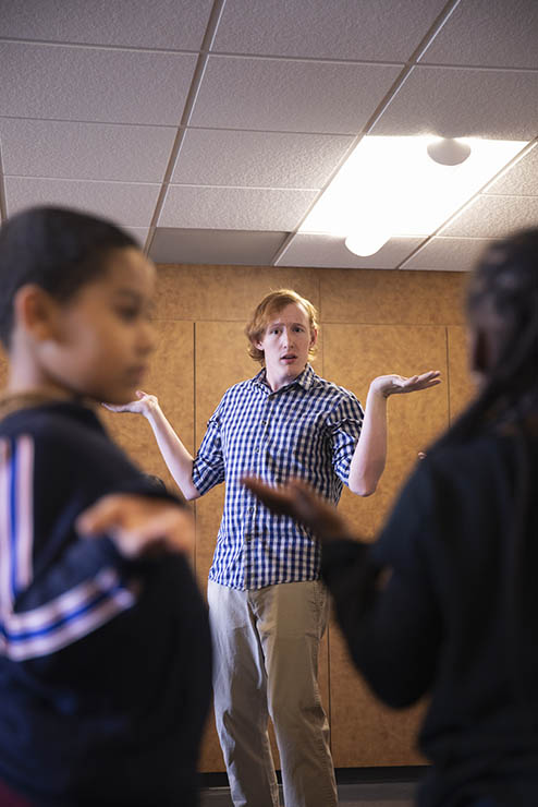 a music education bachelors student performs a group song with hand motions in front of a group of children
