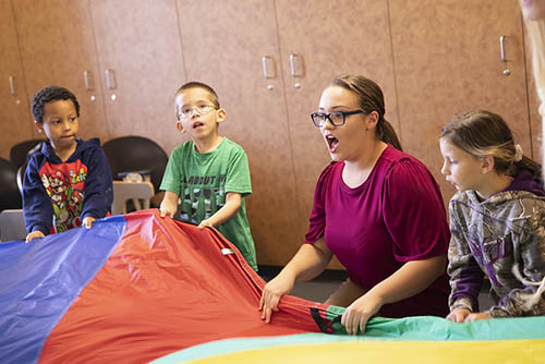 a bachelors of music education student sings with a group of small children