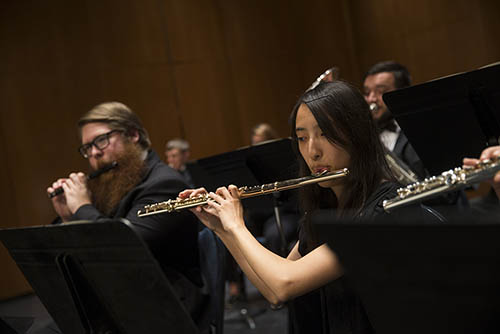bachelor of music degree students play wind instruments during a symphony performance