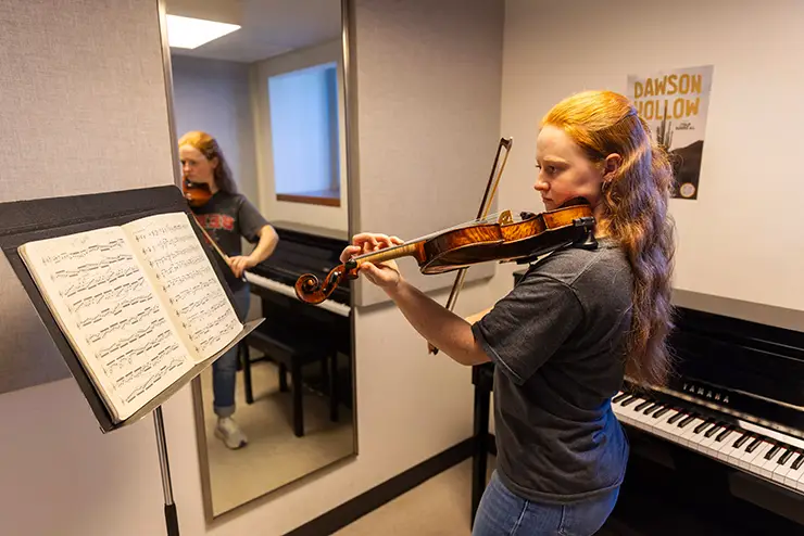 a SEMO music student practices her violin in the practice room