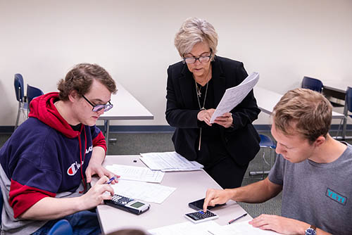 two students in a class for a bachelors in accounting at southeast missouri state work with their instructor on a class assignment