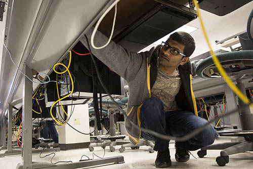 a computer science major works on networking a computer in a computer lab