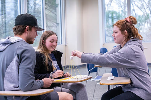 three bsba degree students at Southeast Missouri State work together to build a spaghetti and marshmallow construct